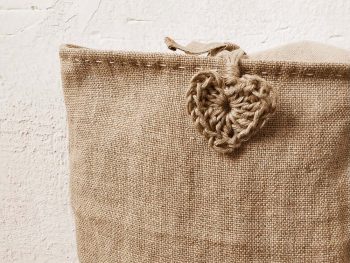 funda de lino para cojín con detalle de corazón en crochet